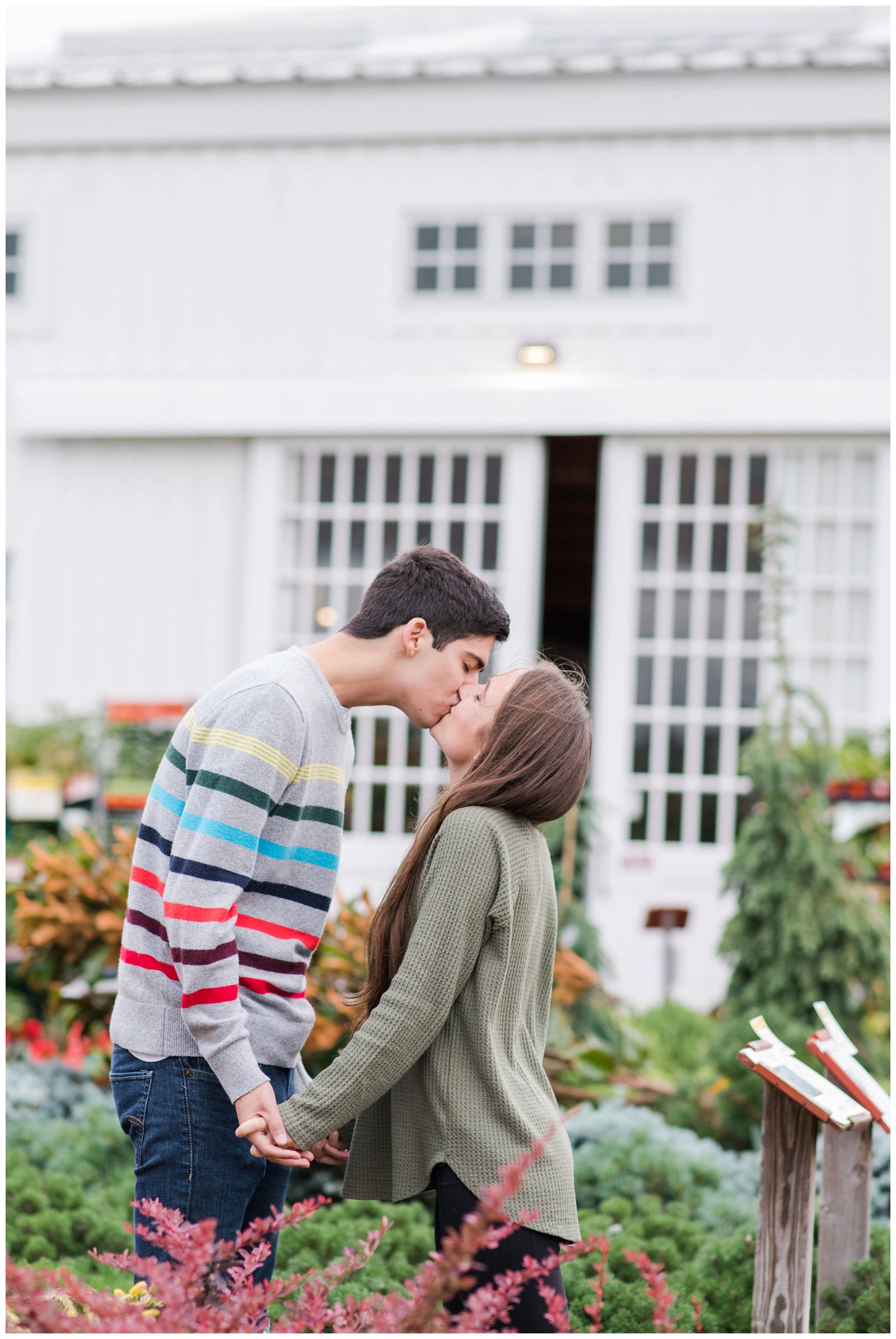 groom kisses bride in front of Oakland Nursery during New Albany Ohio engagement session