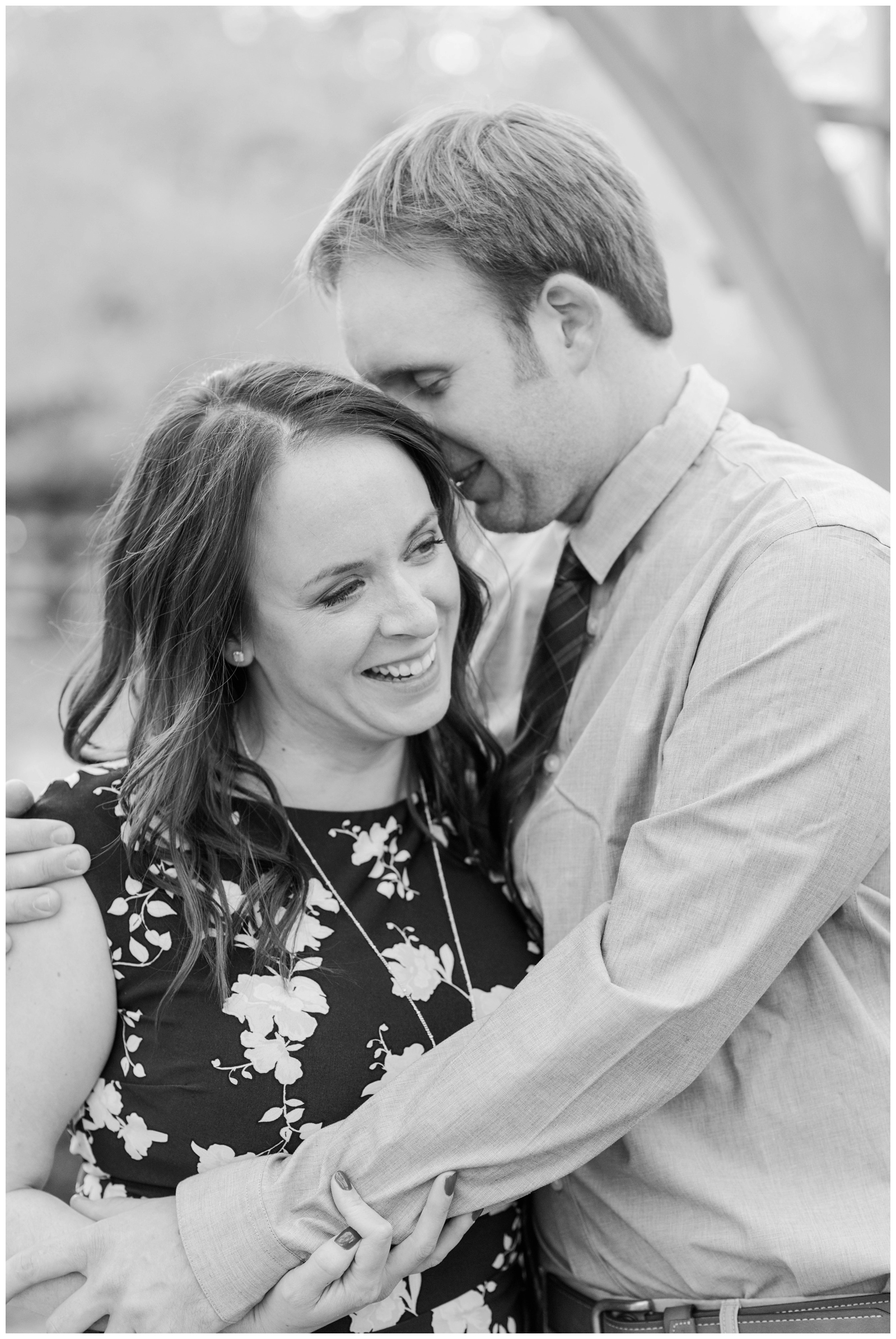 groom whispers in bride-to-be's ear during engagement portraits at Franklin Park Conservatory