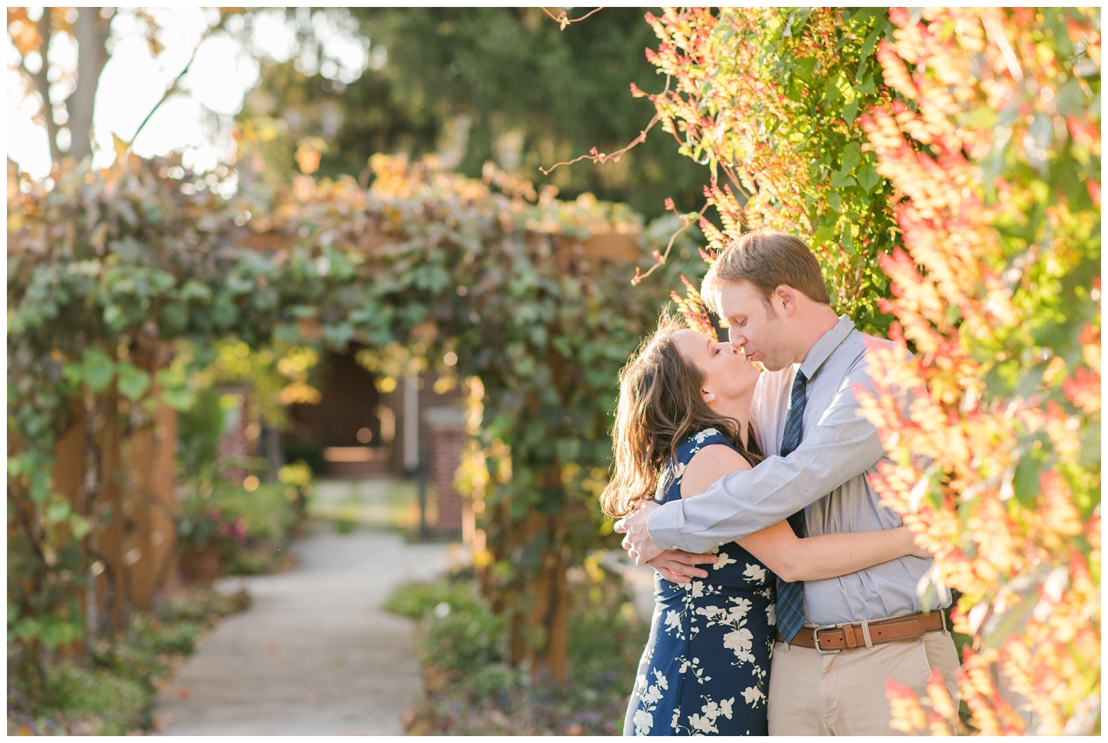 fall engagement photo at Franklin Park Conservatory with bride and groom kissing