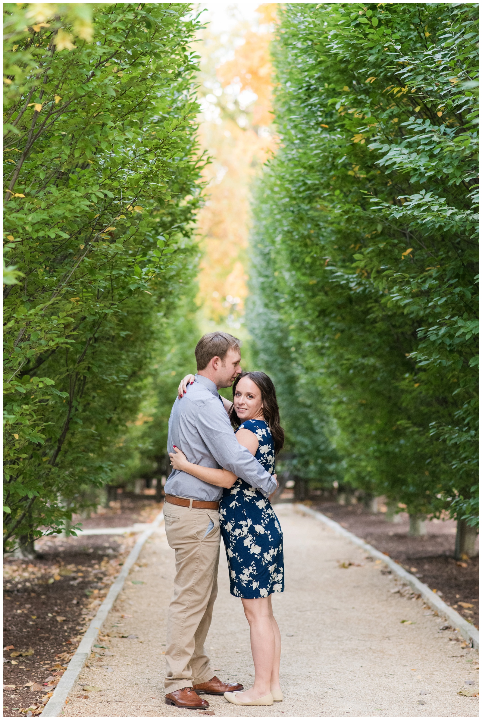 bride in blue dress with flowers hugs groom in blue shirt and khakis in walkaway at Franklin Park Conservatory