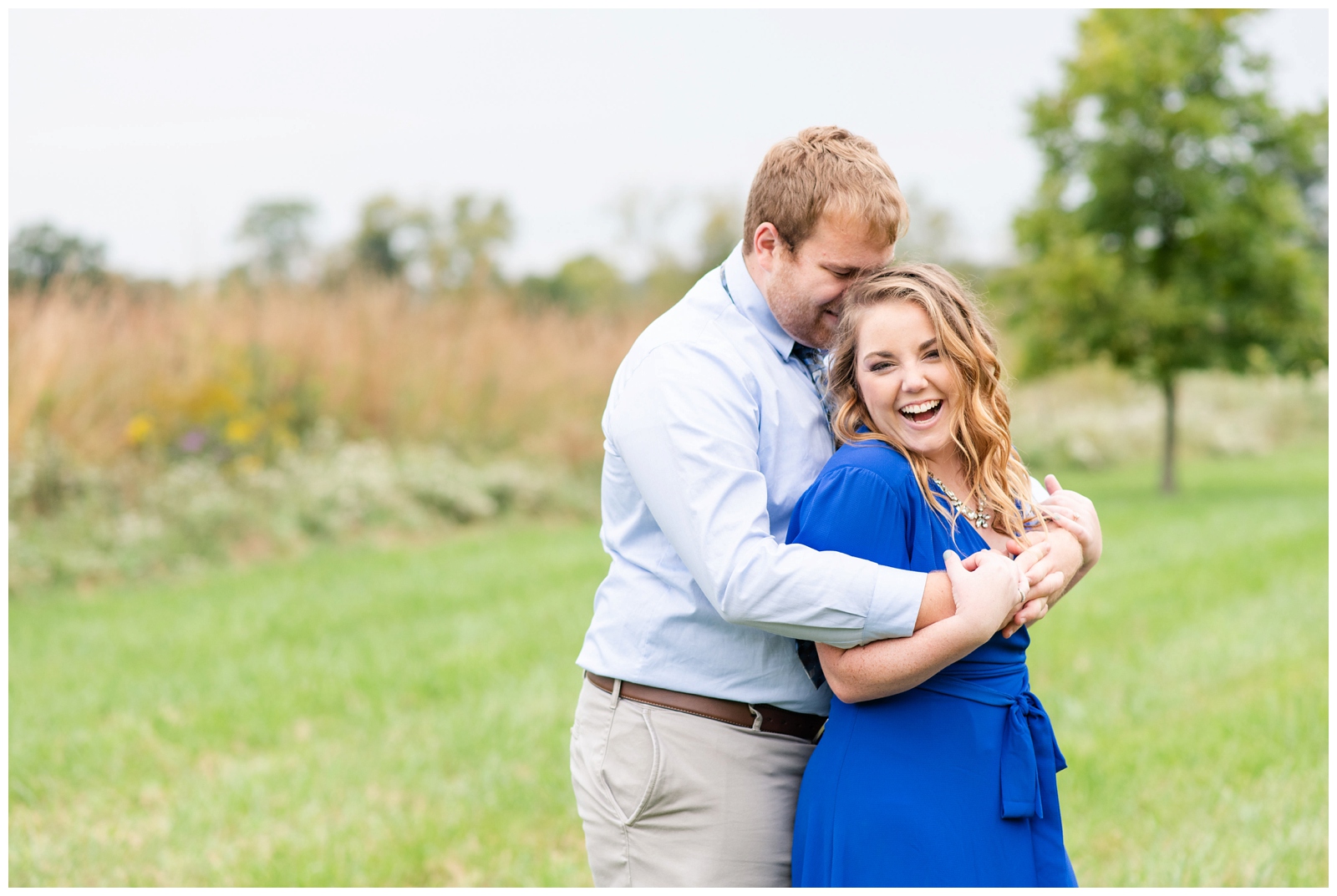 engaged couple snuggles and laughs during summer engagement session Dawes Arboretum
