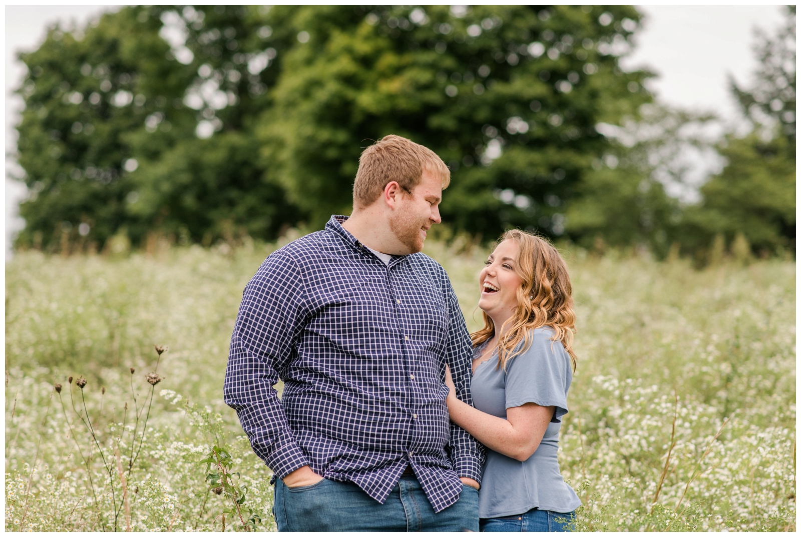 engaged couple smile and laugh at each other at Dawes Arboretum in Newark OH