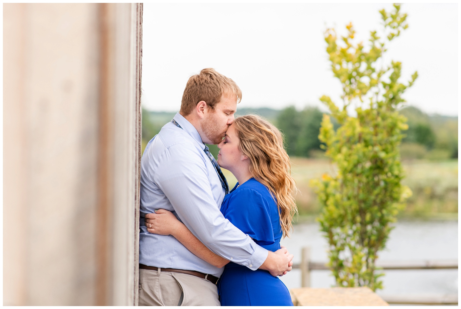 groom kisses bride-to-be on forehead during summer engagement session Dawes Arboretum
