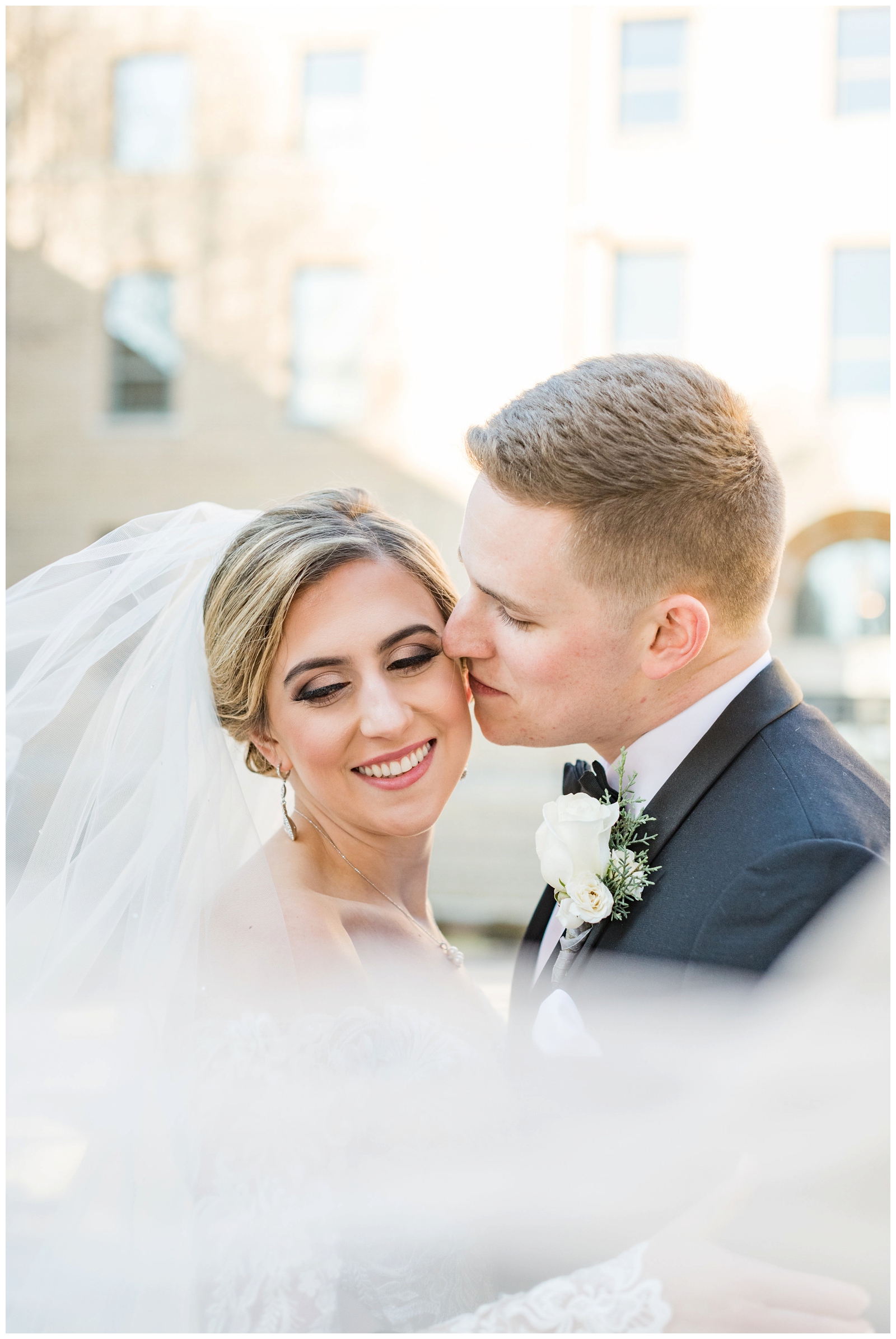Christmas wedding portraits at St. Charles Preparatory School of bride with veil and groom in classic tux