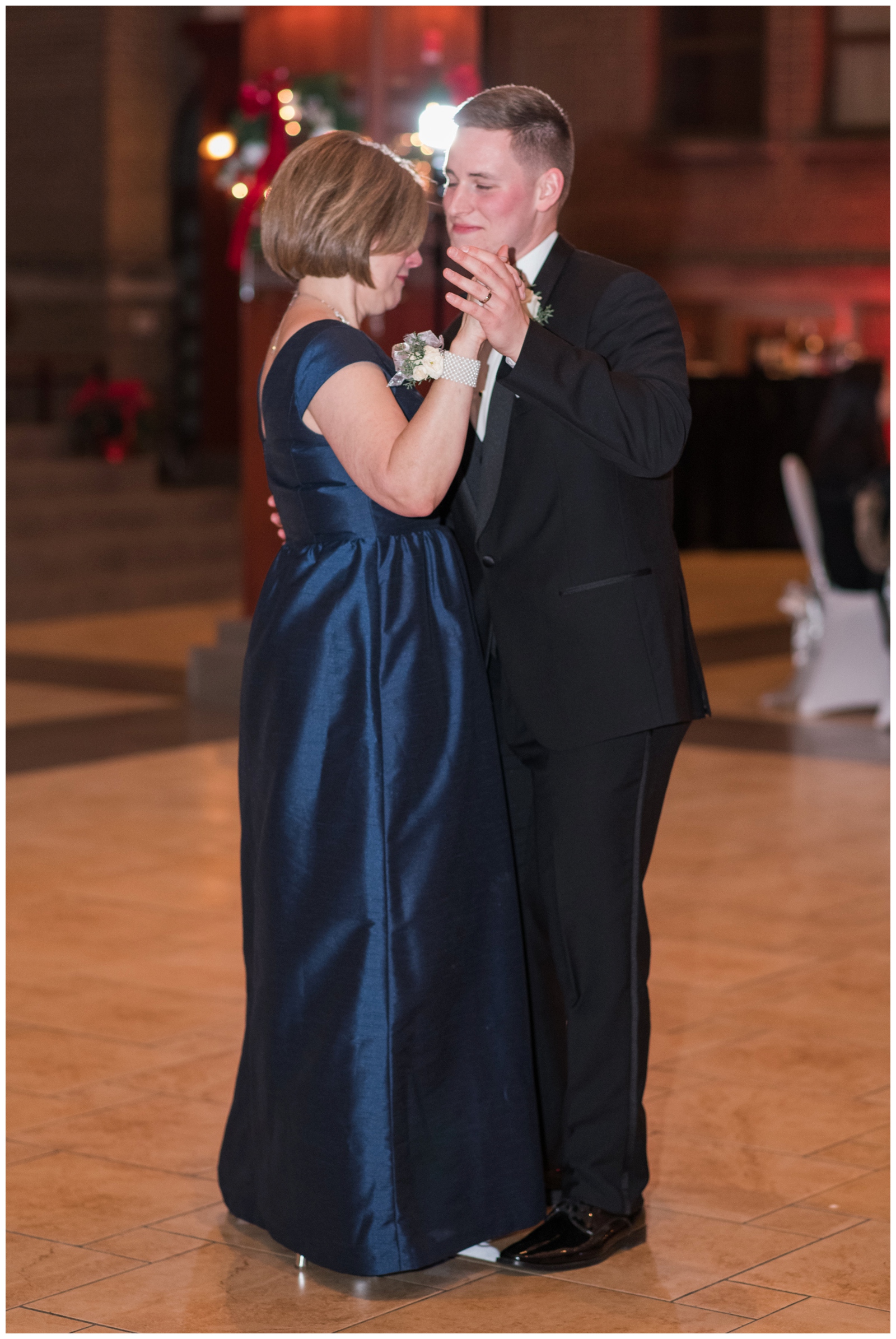 groom dances with mom in navy gown at St. Charles Preparatory School
