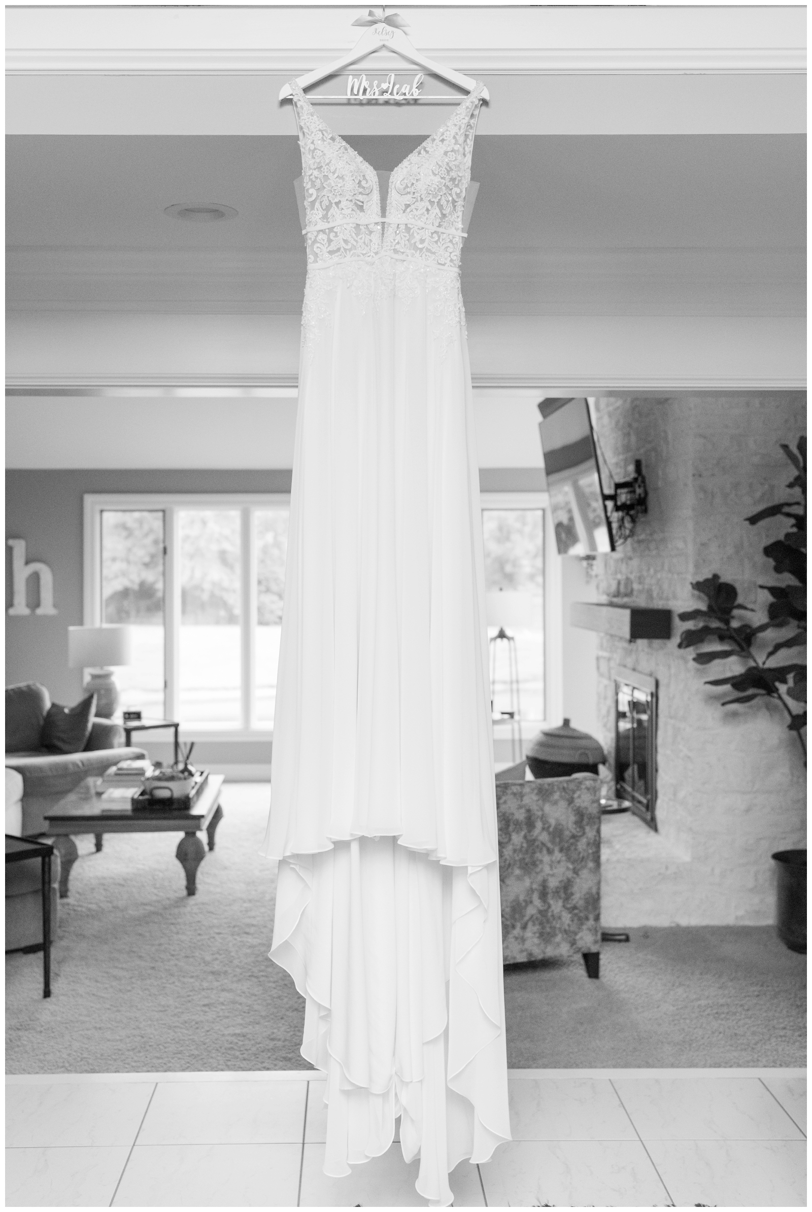bride's wedding dress hangs in home