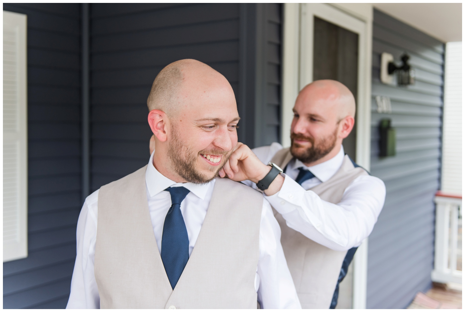 groomsman adjusts collar for groom around vest