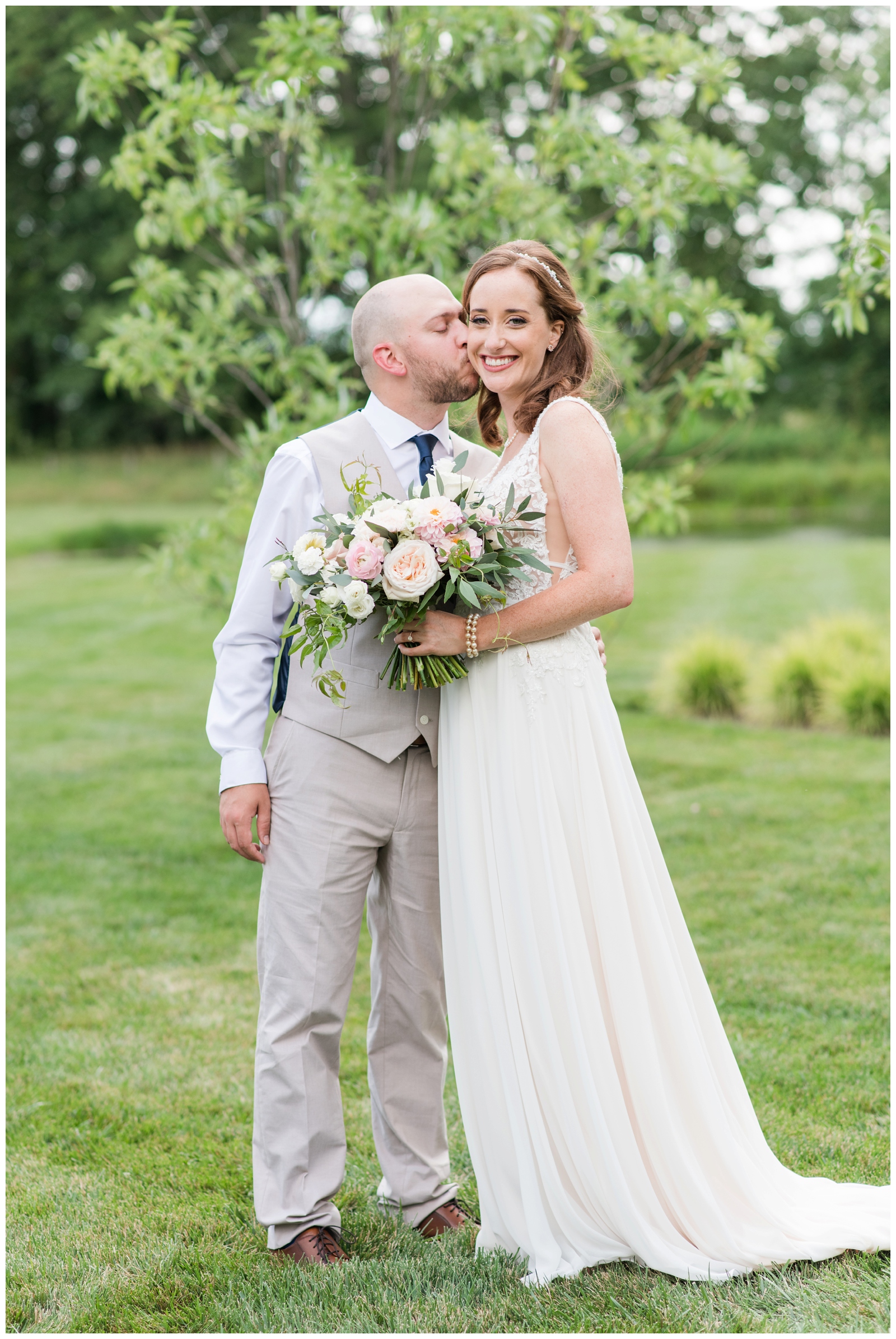 summer wedding portraits at Oak Grove Jorgensen Farms of groom kissing bride's cheek