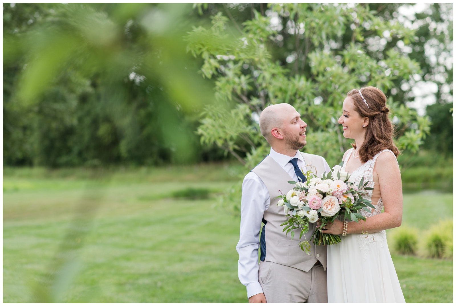 bride and groom look at each other under tree at Oak Grove Jorgensen Farms