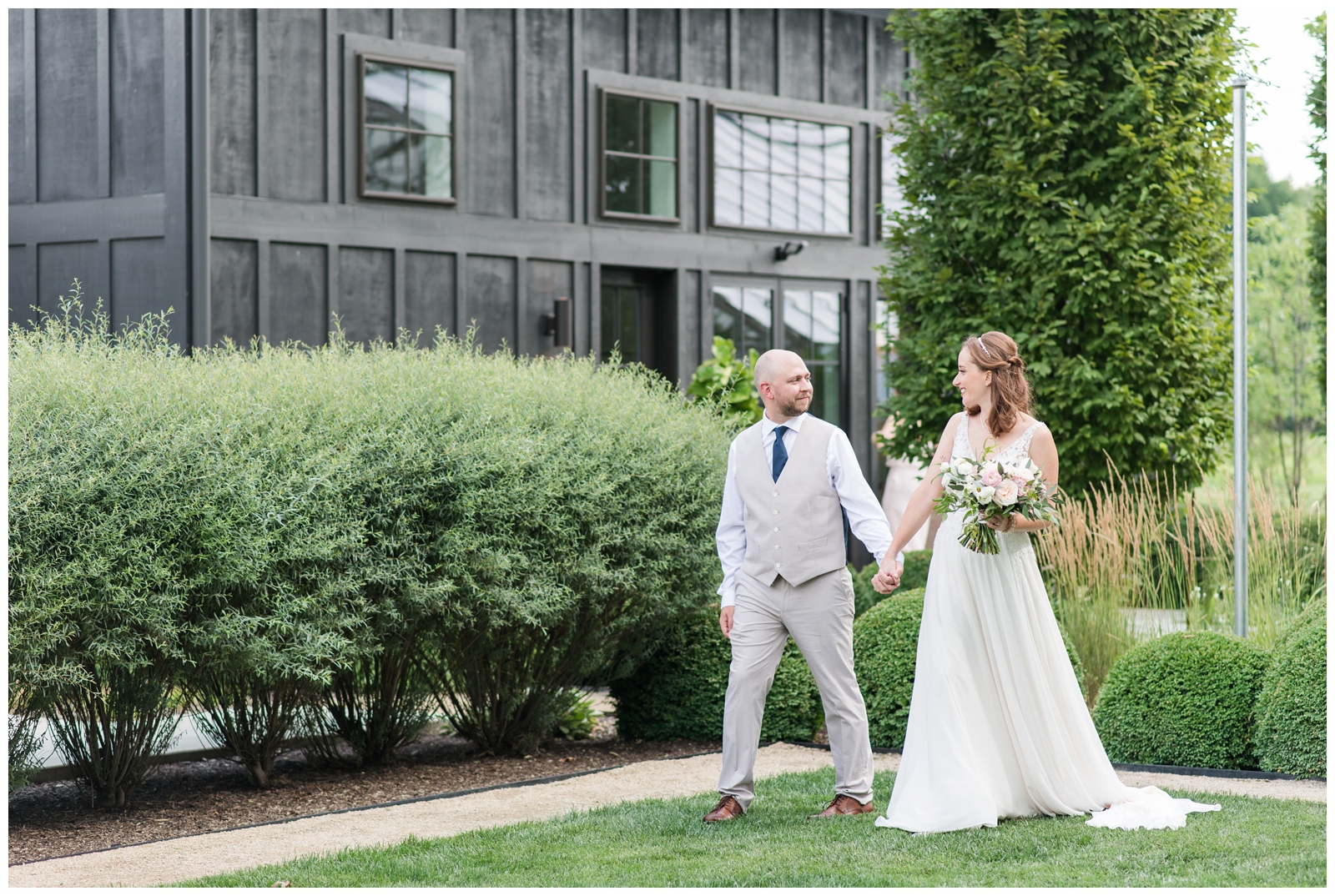 bride and groom hold hands while walking the grounds at Oak Grove Jorgensen Farms