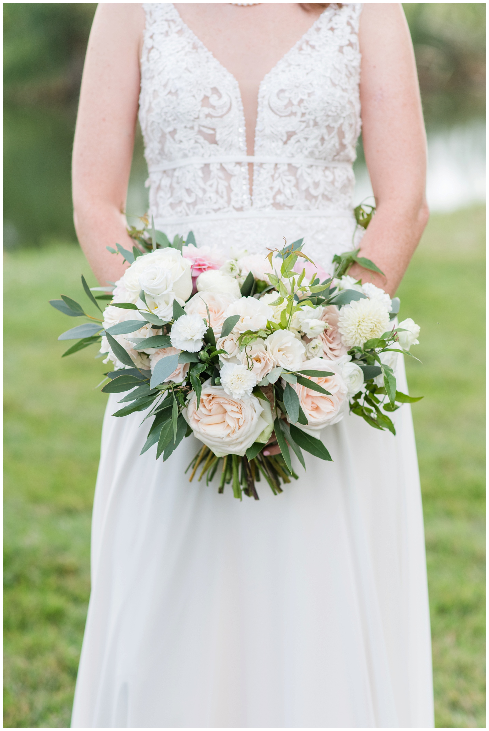 bride holds bouquet with pale flowers and pops of pinks