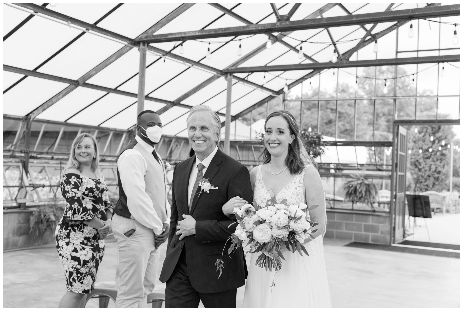 father of the bride walks bride down the aisle in greenhouse at Oak Grove Jorgensen Farms