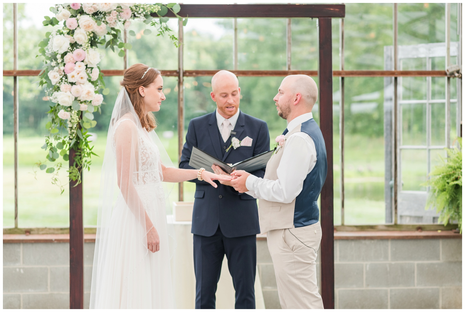 bride and groom exchange rings during wedding ceremony at Oak Grove Jorgensen Farms