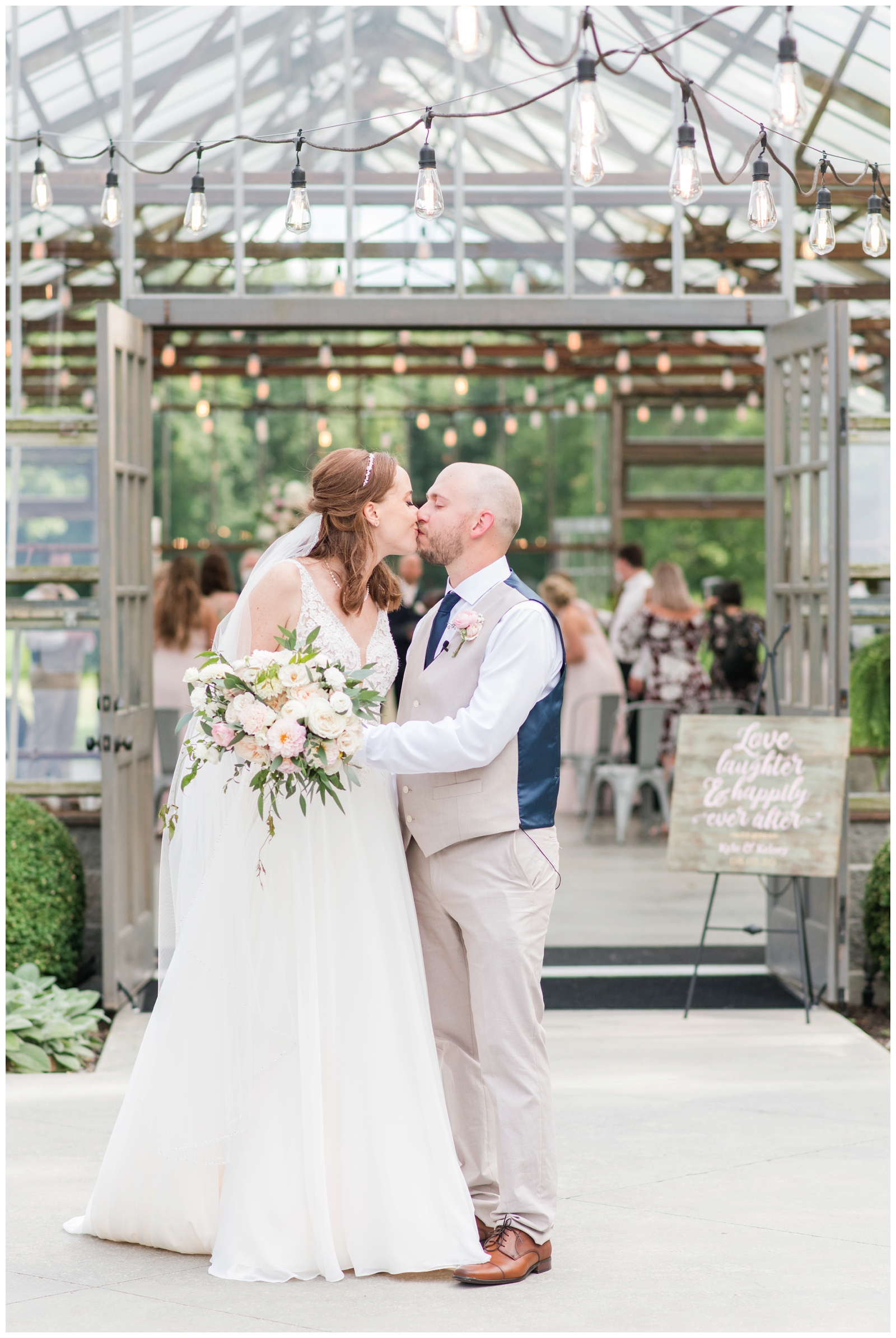 bride and groom kiss outside greenhouse at Oak Grove Jorgensen Farms