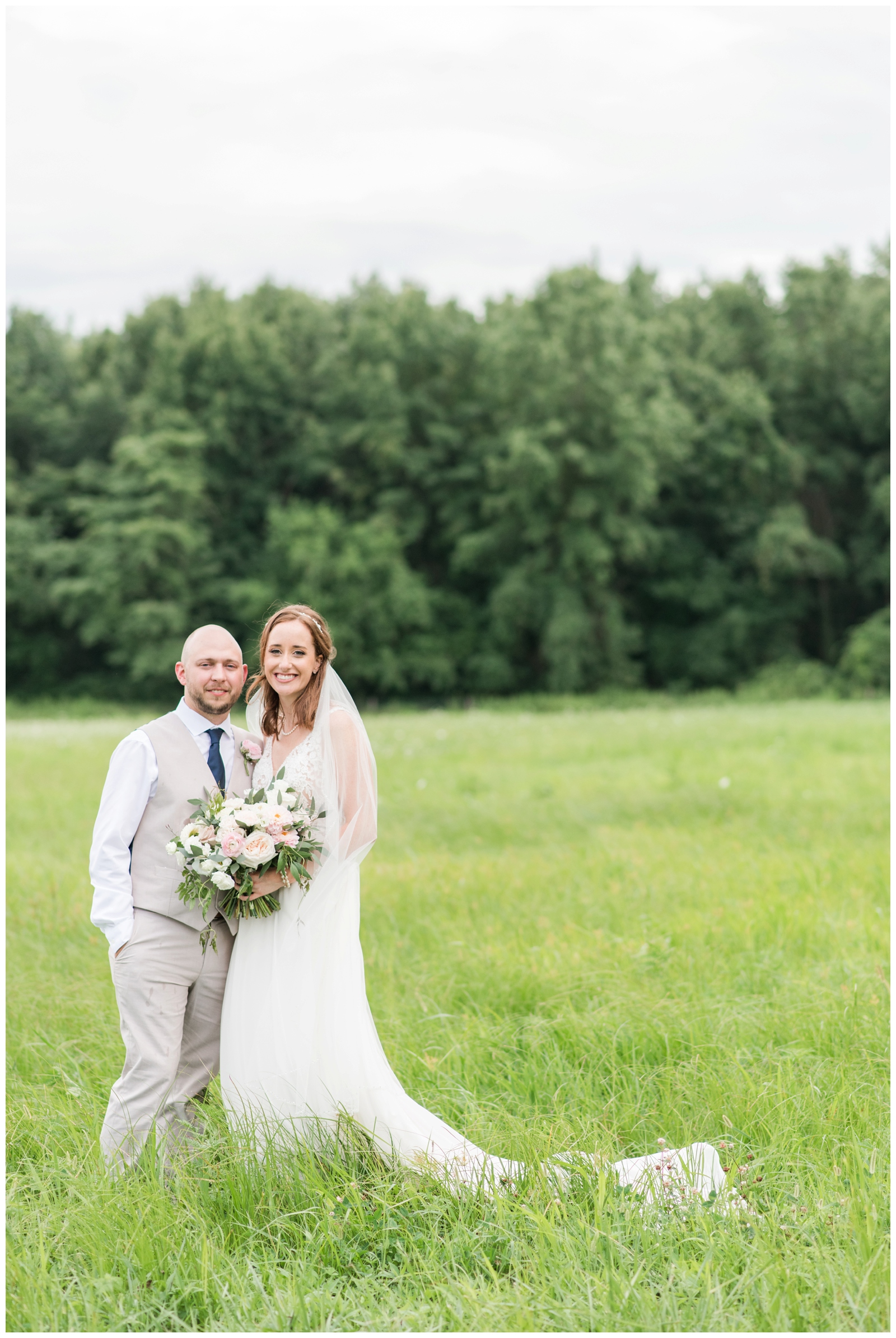 bride and groom pose in green field at Oak Grove Jorgensen Farms