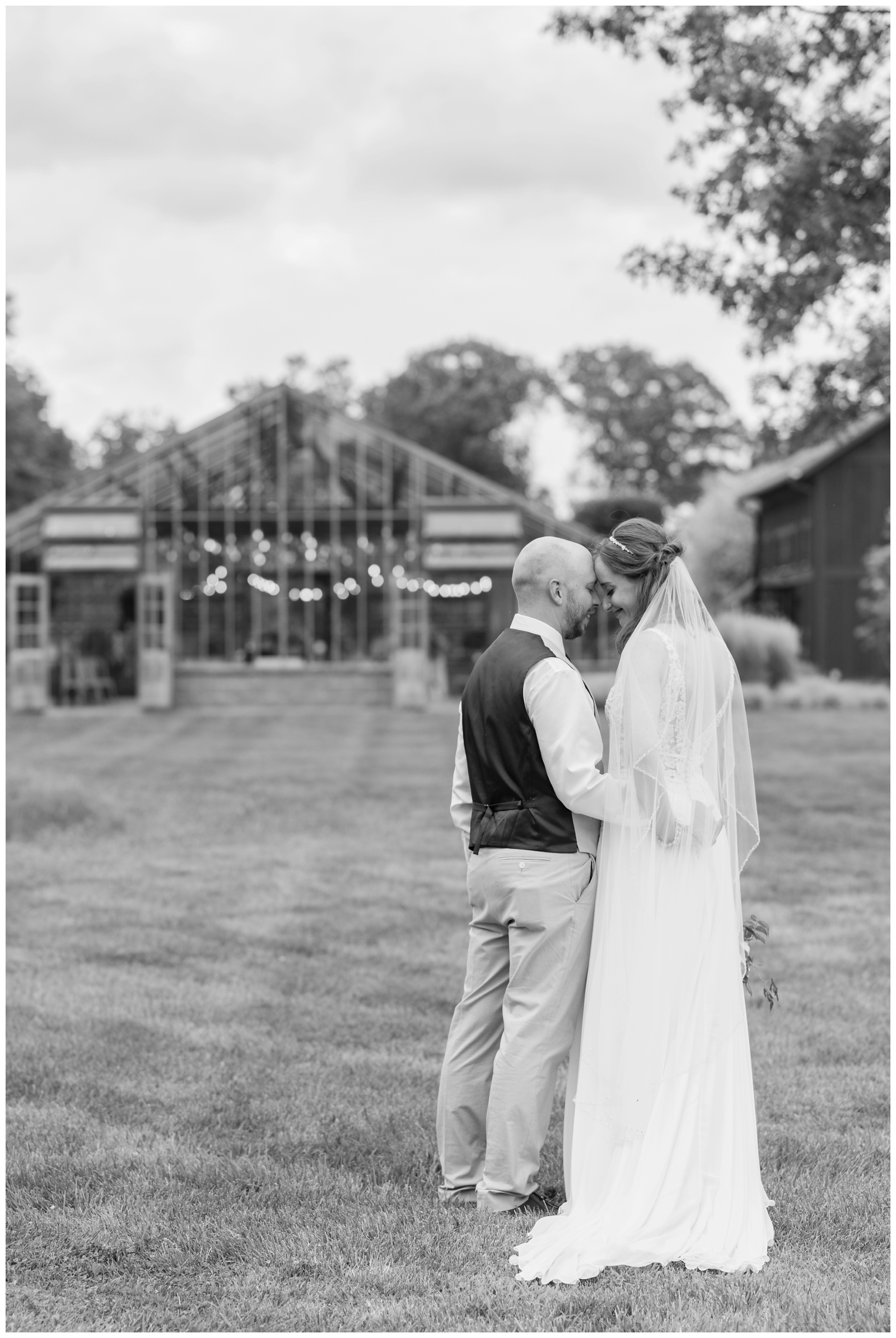 bride and groom touch foreheads standing outside Oak Grove Jorgensen Farms greenhouse