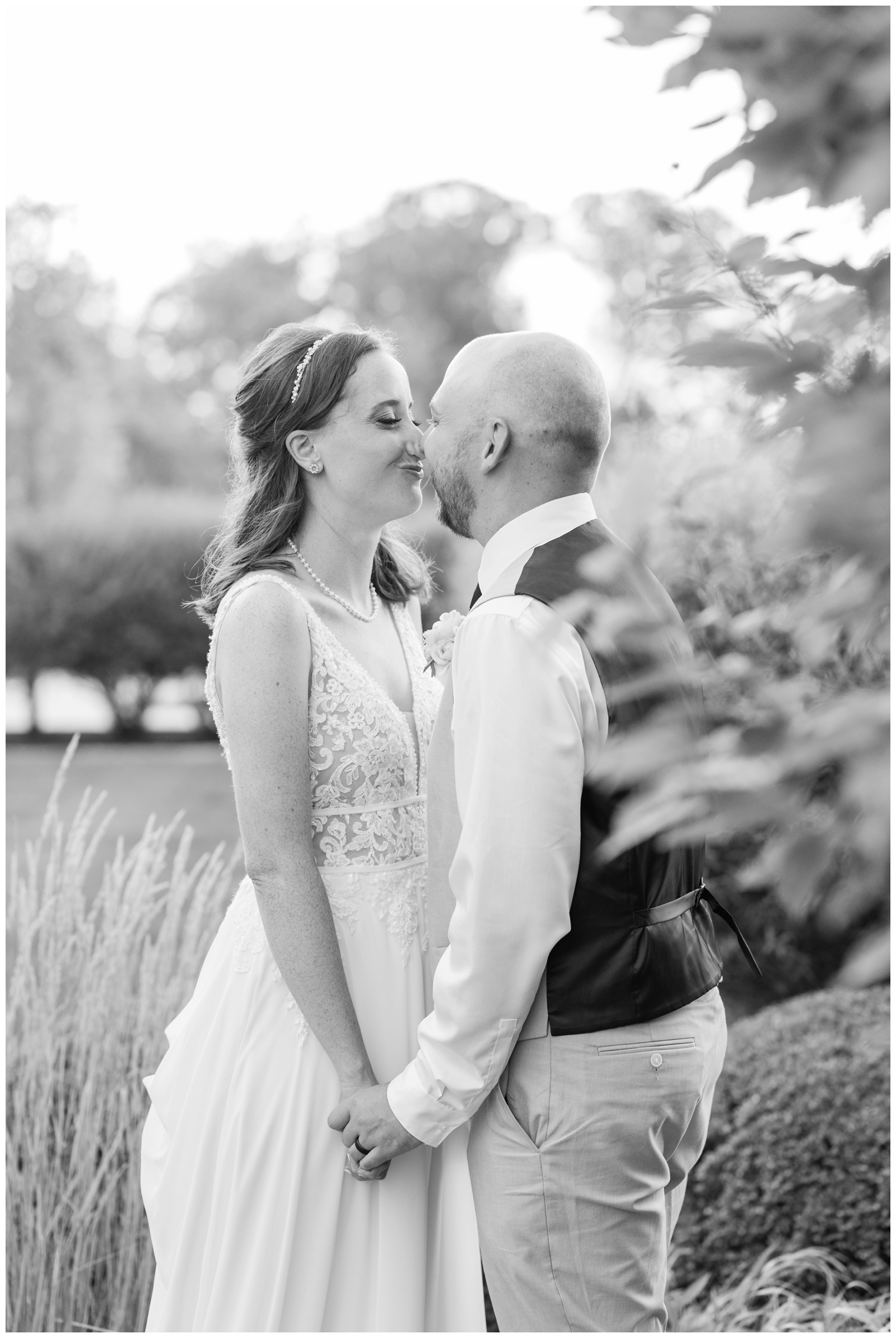 newlyweds smush noses and laugh during wedding portraits in Ohio
