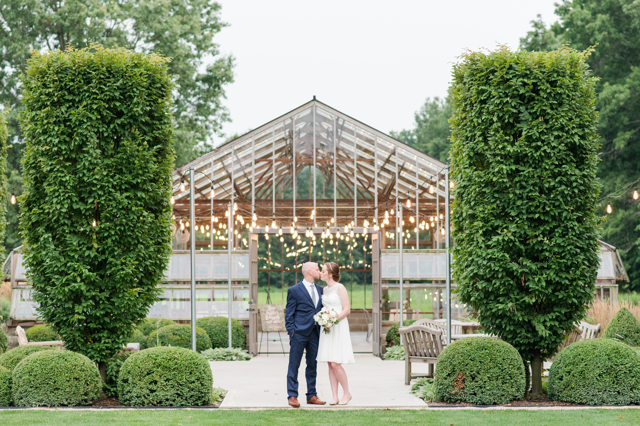 Newlyweds kiss at the greenhouse entrance during their Jorgensen Farm Wedding