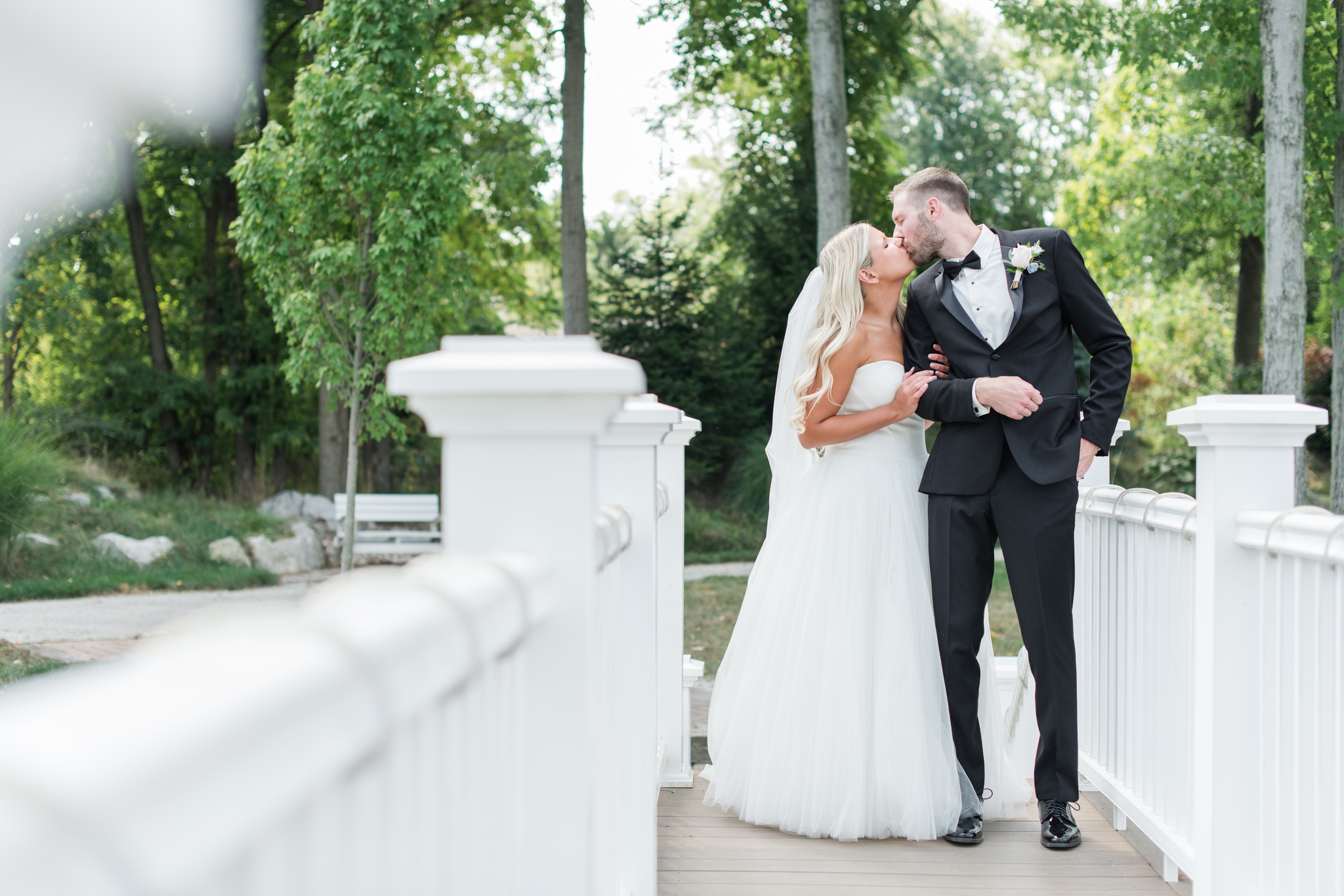 Newlyweds kiss on the white bridge while standing in the center