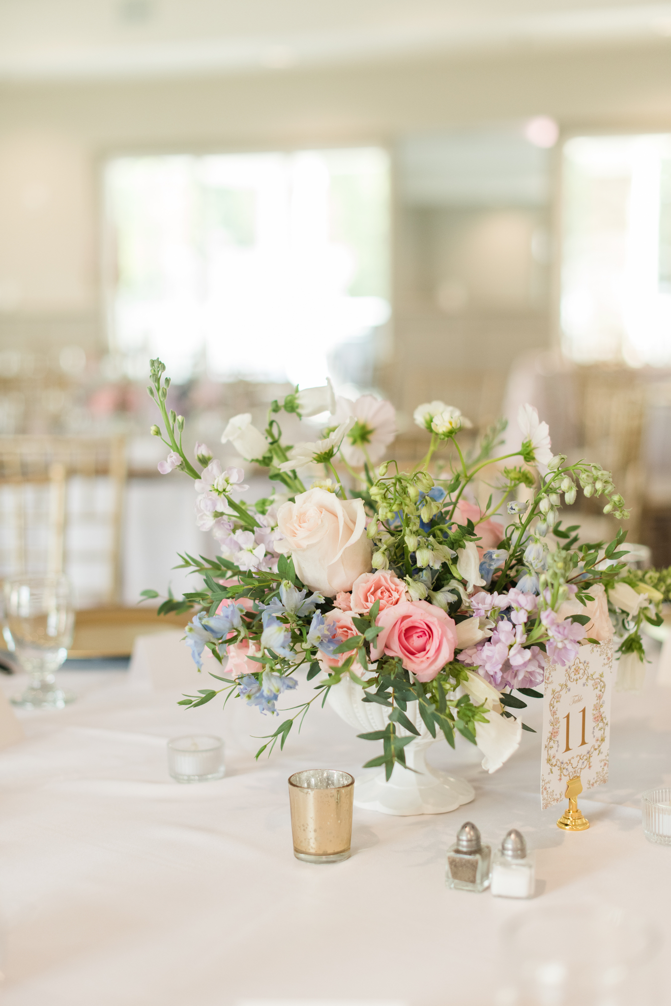 Details of a colorful floral centerpiece on a reception table with white linen