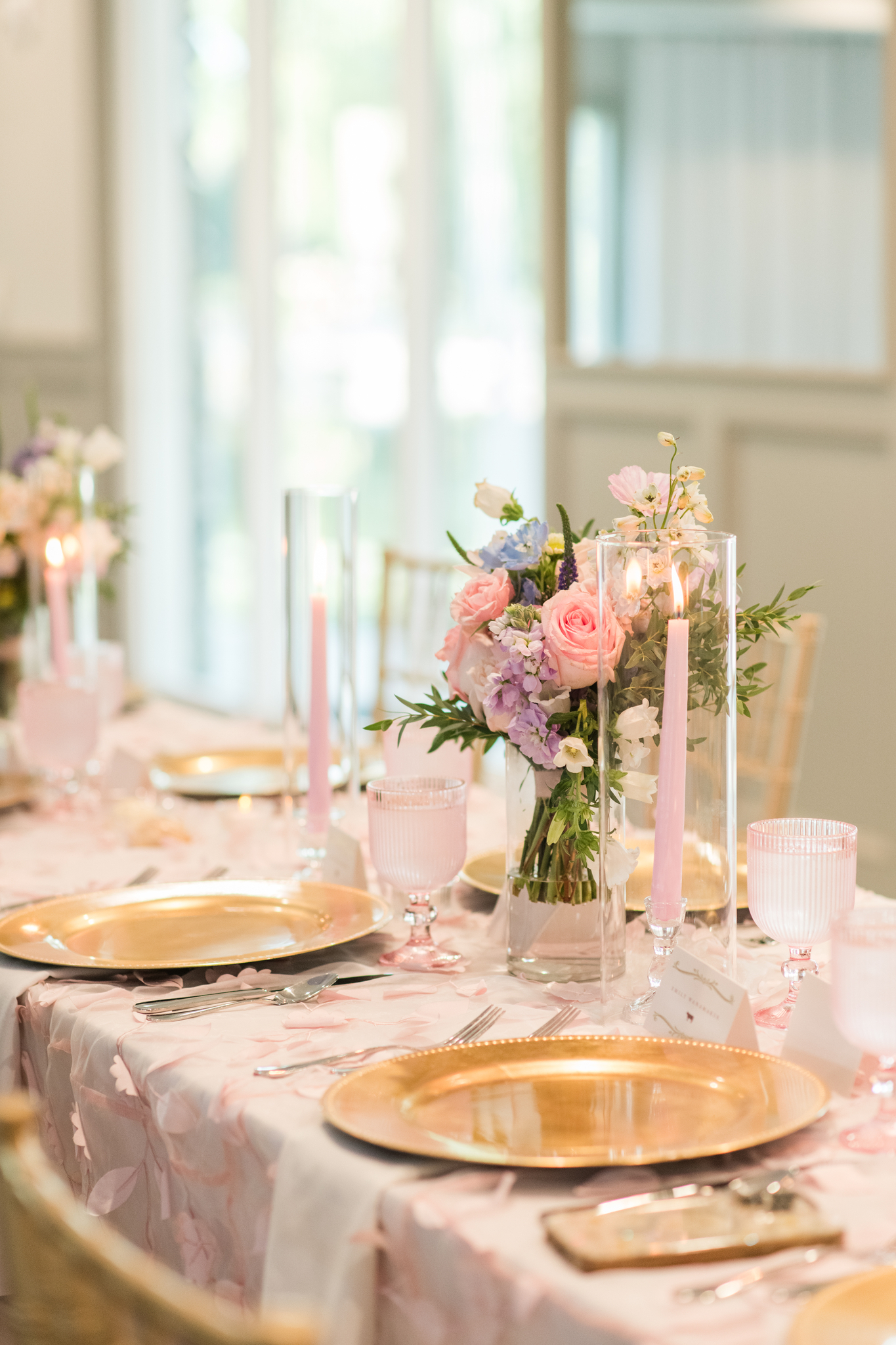 Details of a pink and gold Swan Lake Event Center wedding reception table set up with candles and flowers